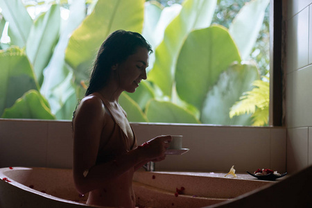 印尼巴厘岛豪华温泉酒店，坐在热带花卉石浴管里，喝着带丛林景观的花草茶，有机护肤