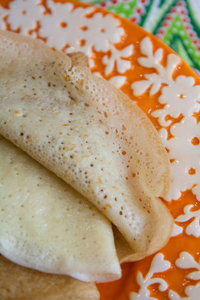 盘子上的新鲜薄开口薄煎饼用黄色蒲公英花装饰食物照片