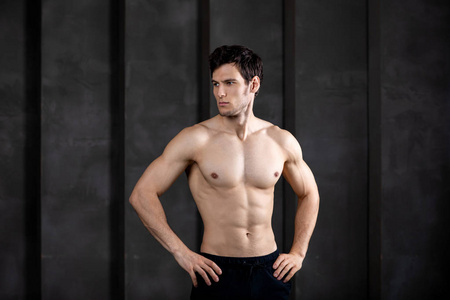 Portrait of muscular guy posing in a studio. 