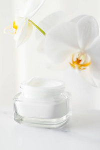 Face cream moisturizer jar and orchid flower, moisturizing skin 