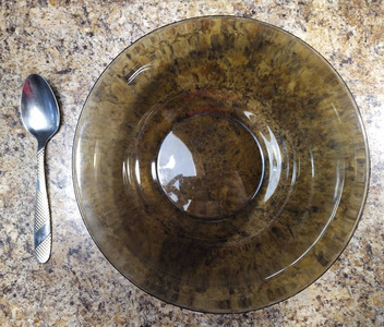 厨房桌子背景上有勺子的碗