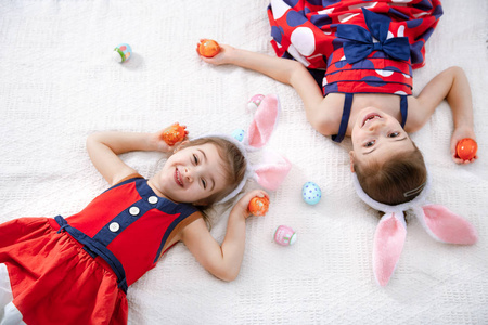 复活节快乐两个有趣可爱的女孩带着复活节彩蛋和兔子耳朵