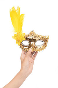 hand holding Golden carnival mask with yellow feathers isolated 