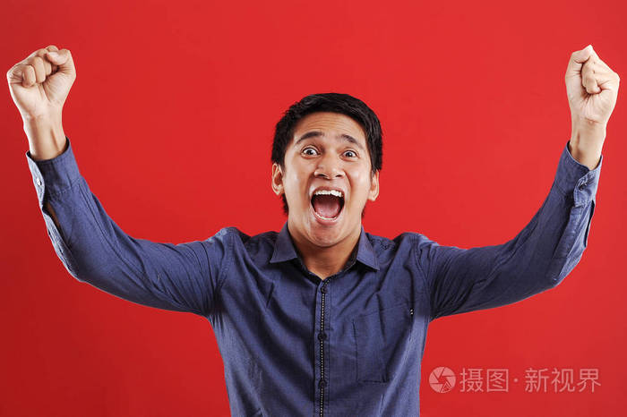 年轻的亚洲男子高兴而兴奋地表示获胜的手势