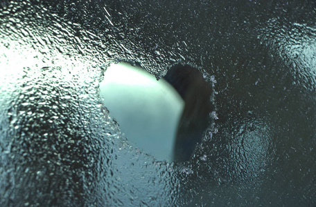 汽车挡风玻璃上的冰和雪冰玻璃上的心.手指画.白霜和霜冻.