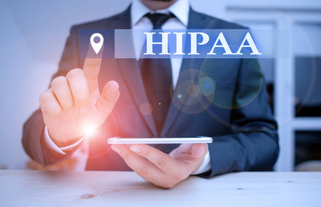 手写文本Hipaa。概念含义首字母缩略词代表健康保险可携带性责任男性穿着正式服装呈现使用高科技智能手机。