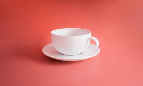 白色咖啡杯隔离在橙色粉彩背景或橙色背景上