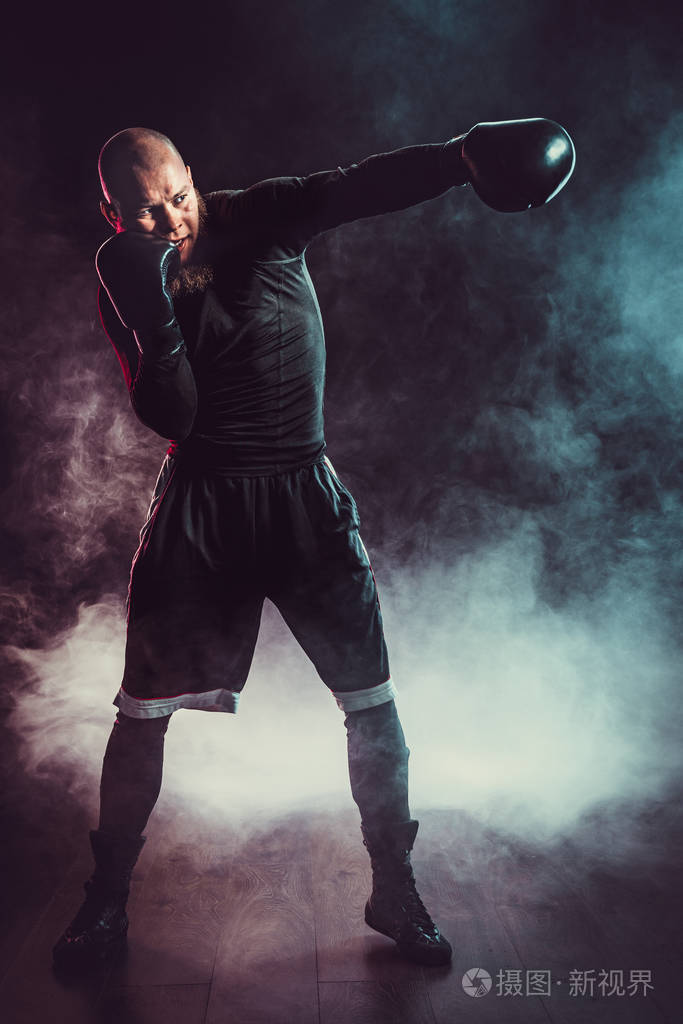 运动员拳击手在黑色背景下与烟雾搏斗拳击运动概念