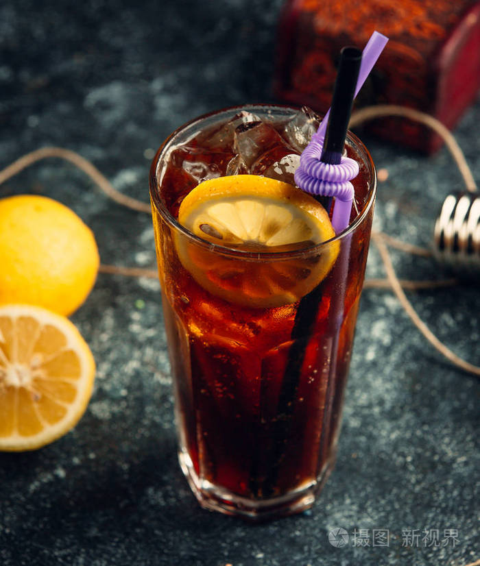 一杯灰色背景的加冰块和柠檬片的可口可乐