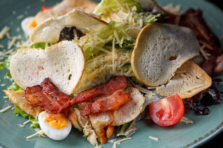 Salad Caesar with bacon, chicken, vegetables, egg and croutons, 