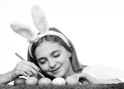 传统的复活节装饰品。复活节假期快乐概念。可爱的微笑小女孩戴着兔子耳朵，装饰着五颜六色的复活节彩蛋。
