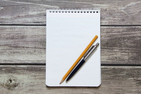 Notepad with a blank white sheet in a checker paper with ball pe