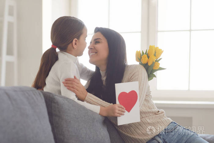 母亲节快乐女儿恭喜拥抱妈妈在房间里捧着一束花