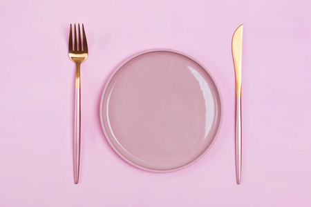 Empty pink plate and elegant cutlery, fork and knife on pastel b