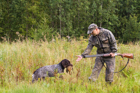 斧子把猎狗把猎物带给猎人照片