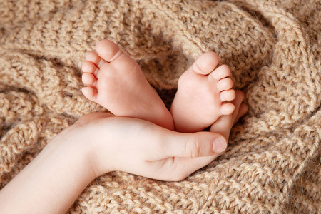 Baby feet in brother hands. Tiny Newborn Babys feet  closeup.  