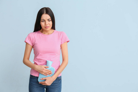 彩色背景下月经来潮的年轻女子 照片