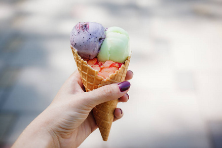 手拿喇叭一个女人手拿着冰激凌华夫饼.户外.闭合照片