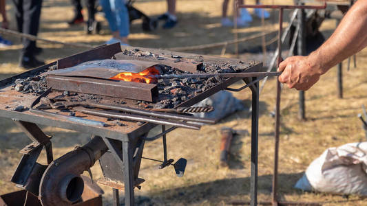 用燃烧的煤工具和炽热的金属工件的铁匠炉。手工生产金属制品。