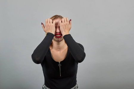 转场阴暗紧张的拨弦穿黑夹克的女孩被吓得绝望,双手捂着头照片
