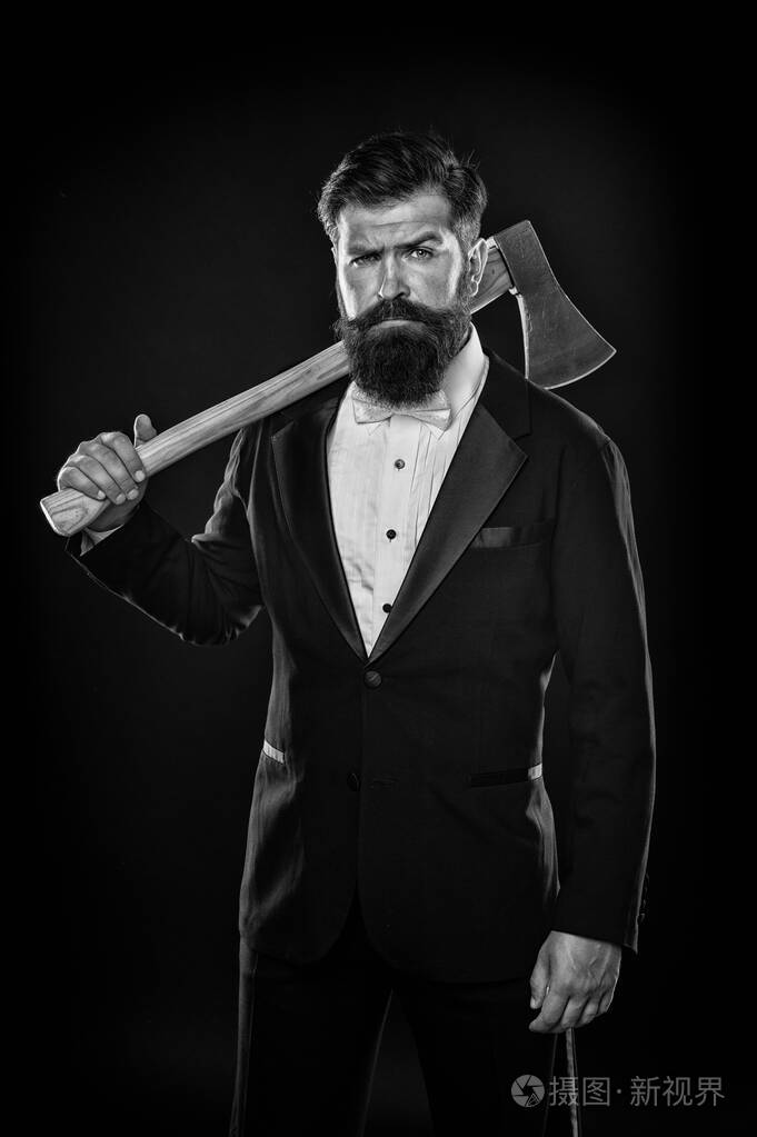自信的商人正装.严肃的男理发师拿着斧头.理发店.有胡子的燕尾服男人.