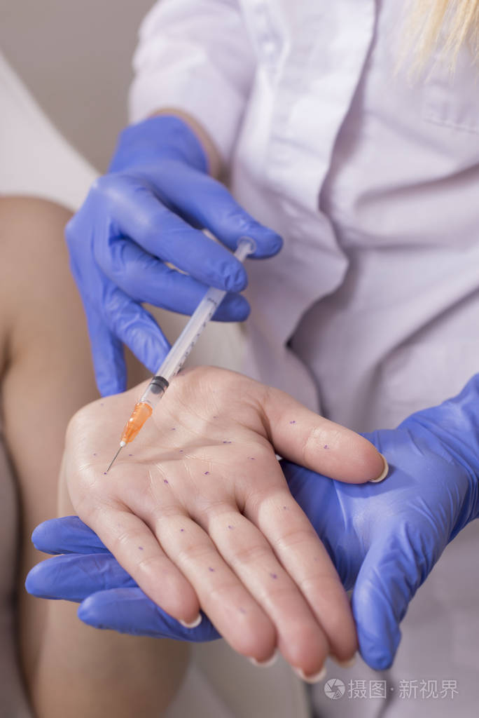 美容师手的特写镜头在手掌上注射的医生美容程序的疾病和过早老化和