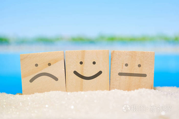 沙滩上模糊的海面上的表情符号的抽象等级度假村评估概念