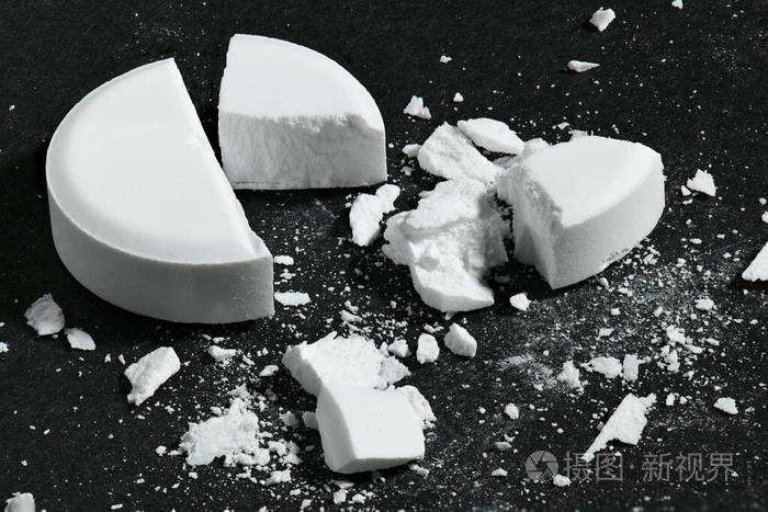 一颗破碎的白色药丸在黑色背景下的宏观照片概念药物和药物治疗保健