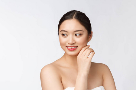 美丽的亚洲女人化妆化妆，女孩用手触摸脸颊和微笑，脸上的美丽完美与健康隔离在白色的背景上。