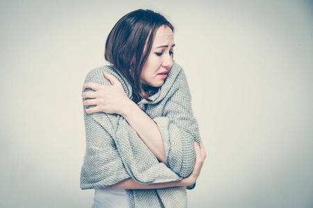 一个穿白色t恤的女孩因为家里寒冷和缺乏暖气而冻僵.健美.照片