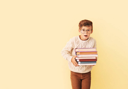 惊讶的小男孩拿着彩色背景的书