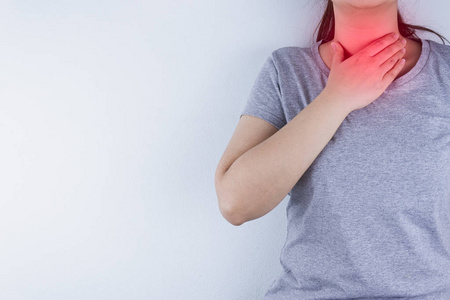 Closeup woman hand touching her neck suffering from sore throat 