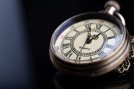  vintage pocket watch on a chain of bronze color closeup on a b