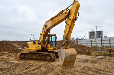 大城市新区建设中的大型亮黄色强力工业重型挖掘机推土机修路专用施工设备