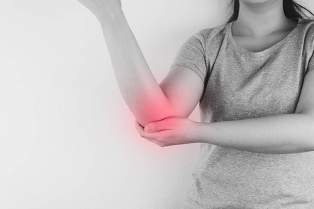 Black and white closeup woman suffering from arm and elbow pain 