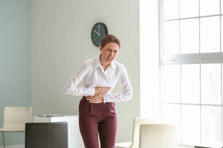 拉肚子的商人手拿着年轻的商人在白色背景下腹痛白底腹痛青年商人女