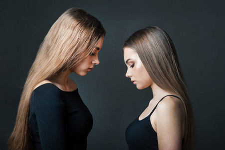 奇怪的姐妹姐妹-女朋友,面对面,在黑暗的背景下剪影照片