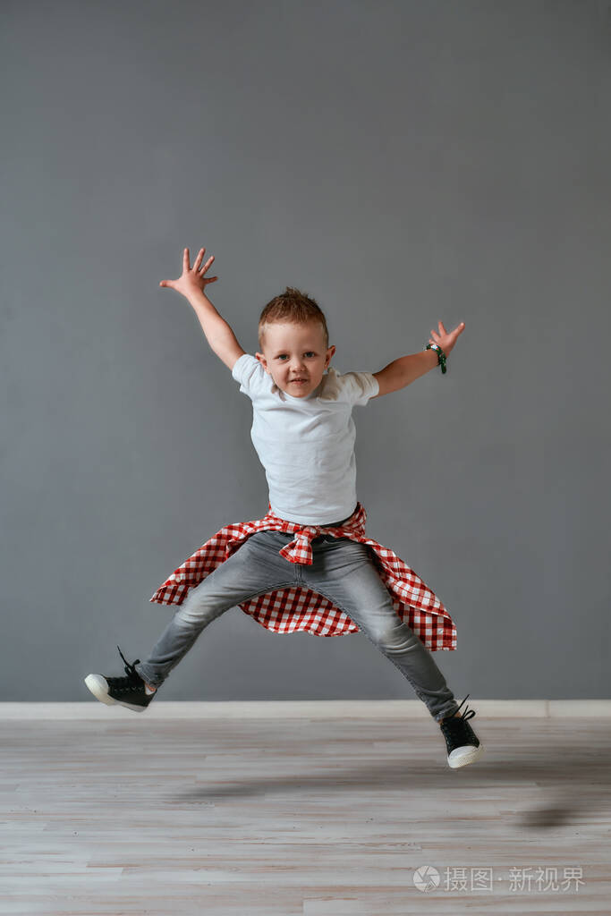 快乐的孩子全长肖像画兴奋的小男孩穿着休闲服跳跃和