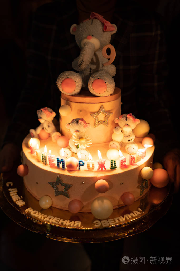 黑暗中有熊和蜡烛的生日蛋糕