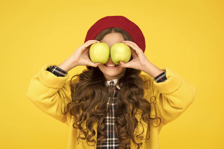 小女孩玩得很开心苹果水果黄色的背景.小孩子拿着健康的水果.