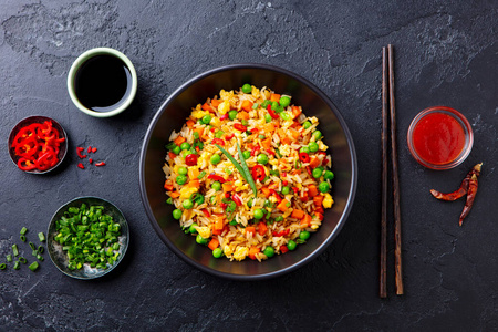 鸡蛋蔬菜亚洲炒饭.深色石头背景.俯视图.照片