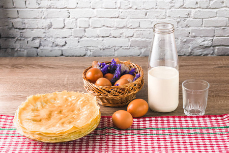 健康甜蜜的早餐。美味的传统薄煎饼，米粉和牛奶放在木桌上