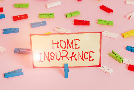 手写文本家庭保险。概念意味着它涵盖个人的损失和损害是房子彩色的衣夹纸空提醒粉红色地板背景办公室别针。