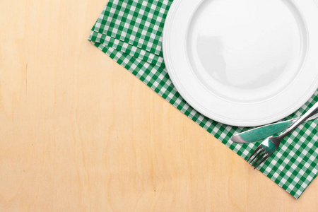 Empty plate and towel over wooden table background.