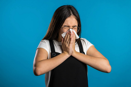 疾病流行病年轻的亚洲女孩用纸巾打喷嚏.