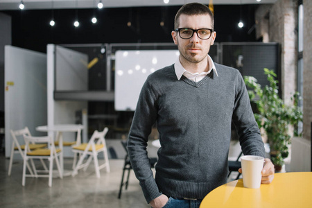 Employee resting with cup of coffee in lecture hall