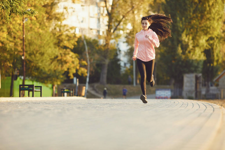 一个穿运动服的女孩在公园里跑步。