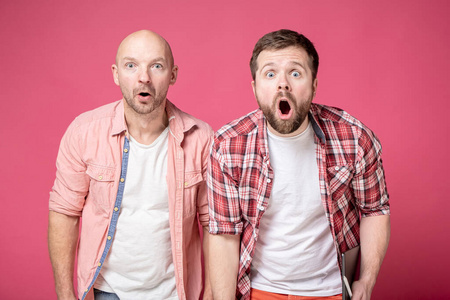 两个男人被惊呆了,他们惊讶地张开嘴,用大眼睛看着镜头,脸上露出有趣