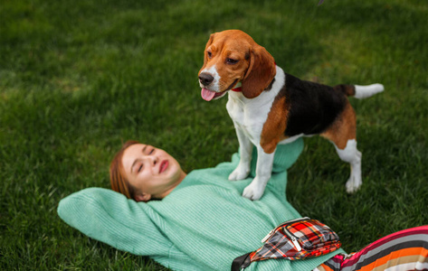 快乐的女人和小猎犬在公园里享受时光