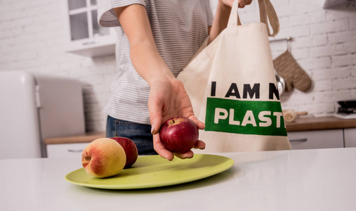 Young girl holding a cloth bag. At the kitchen. I am not plastic